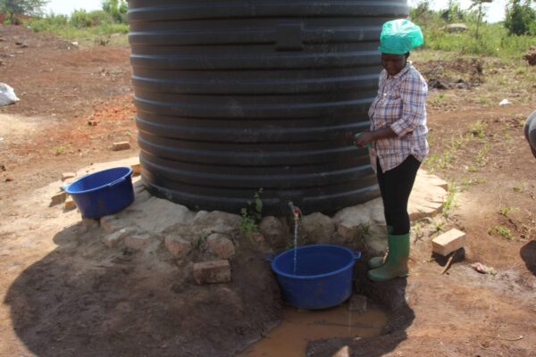 Eine Frau holt Wasser aus unserem Tank